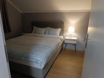 a bedroom with a bed and a night stand with a lamp at Apartman Ana in Borča