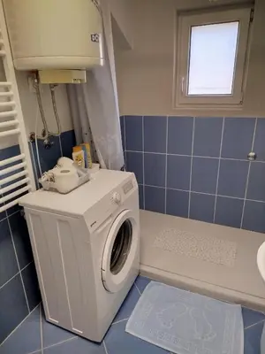 a washing machine in a bathroom with a window at Apartman Ana in Borča
