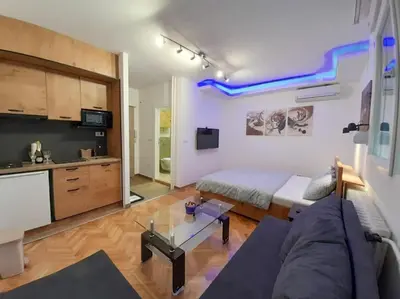 a living room with a couch and a kitchen at Apartment paku 3 New Belgrade in Belgrade