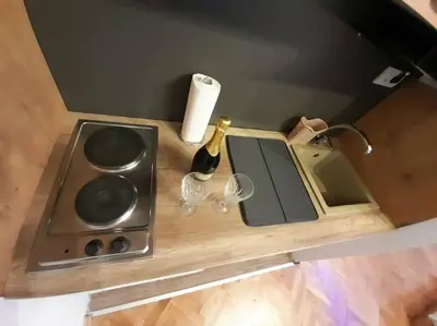 a counter with a bottle of wine and a sink at Apartment paku 3 New Belgrade in Belgrade
