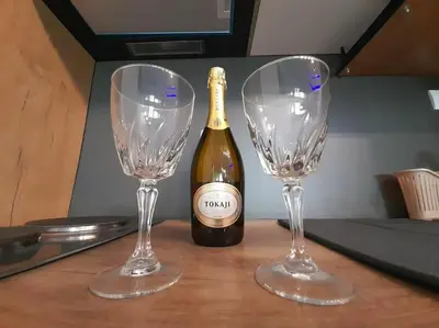 two wine glasses sitting on a table with a bottle of wine at Apartment paku 3 New Belgrade in Belgrade