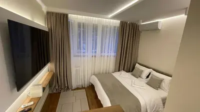 a hotel room with a bed and a large window at Luka Luxury Suite in Belgrade