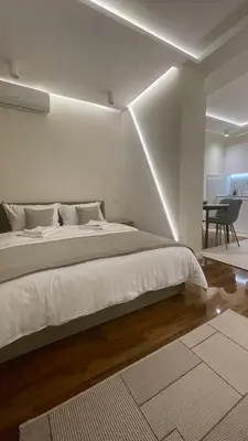 a bedroom with a large white bed and a table at Luka Luxury Suite in Belgrade
