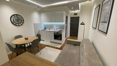 a living room with a table and a kitchen at Luka Luxury Suite in Belgrade