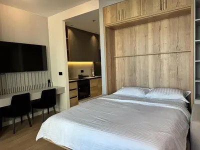 a bedroom with a large white bed and a desk at BW Lux Apartments in Sajmište