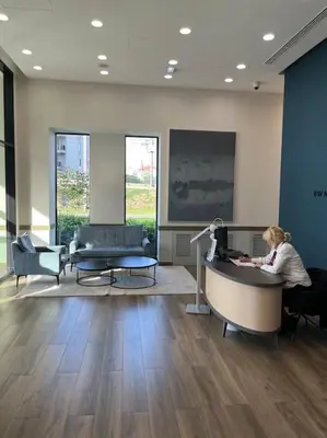 a woman sitting at a desk in a lobby at Pleasure Apartment - Belgrade Waterfront in Sajmište