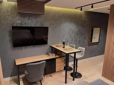 a dining room with a table and a television on a wall at Pleasure Apartment - Belgrade Waterfront in Sajmište