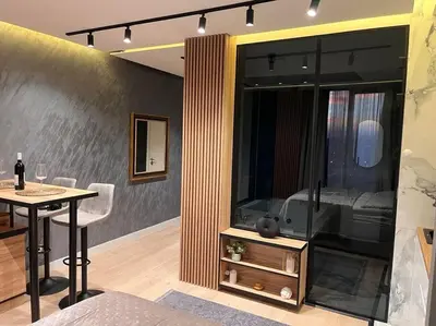 a living room with a table and a bedroom at Pleasure Apartment - Belgrade Waterfront in Sajmište