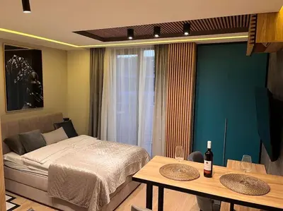 a bedroom with a bed and two tables with wine bottles at Pleasure Apartment - Belgrade Waterfront in Sajmište