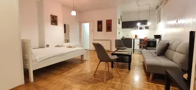 a living room with a bed and a couch at Olimp Zvezdara in Mirijevo
