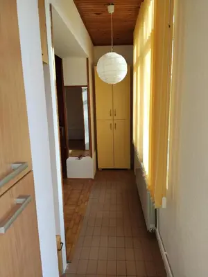 a hallway with a tile floor and a light fixture at Olimp Zvezdara in Mirijevo