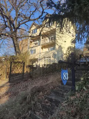 a house with a sign in front of a fence at Olimp Zvezdara in Mirijevo