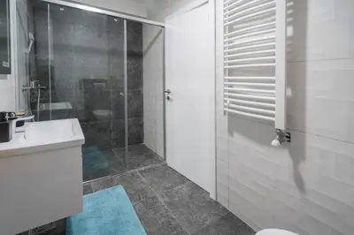 a bathroom with a toilet and a sink and a shower at Apartment Nar in Karaburma