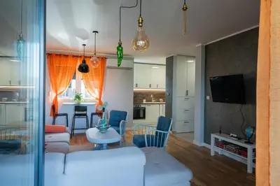 a living room and kitchen with a table and chairs at Apartment Nar in Karaburma