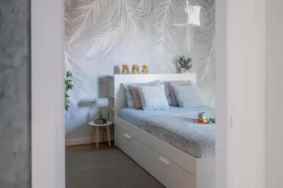 a bedroom with a bed with a white wall at Apartment Nar in Karaburma