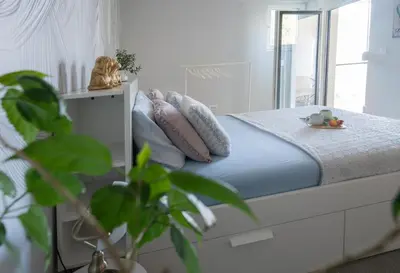 a bedroom with a bed with blue sheets and pillows at Apartment Nar in Karaburma
