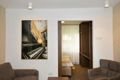 a living room with a picture of a piano on the wall at Piano Luxe Apartment with Sauna in Novi Beograd