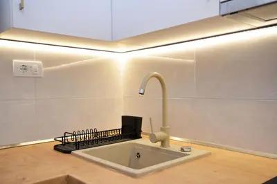 a kitchen with a sink with a laptop on it at Piano Luxe Apartment with Sauna in Novi Beograd