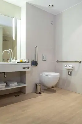 a white bathroom with a toilet and a sink at Radisson Collection Hotel, Old Mill Belgrade in Belgrade