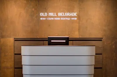 a white desk in a room with a sign on the wall at Radisson Collection Hotel, Old Mill Belgrade in Belgrade