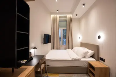 a bedroom with a bed and a desk and a television at Hop Inn Rooms & Suites in Belgrade