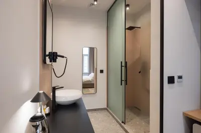 a bathroom with a white sink and a mirror at Hop Inn Rooms & Suites in Belgrade