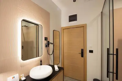 a bathroom with a sink and a mirror at Hop Inn Rooms & Suites in Belgrade