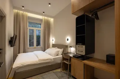 a bedroom with a bed and a desk and a television at Hop Inn Rooms & Suites in Belgrade