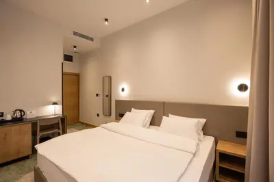 a bedroom with a large white bed in it at Hop Inn Rooms & Suites in Belgrade