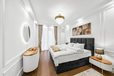 a white bedroom with a large bed and a table at BW Royal Dream in Belgrade