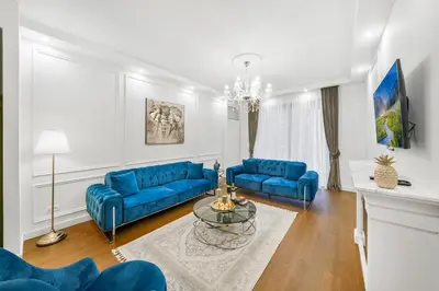 a living room with blue couches and a table at BW Royal Dream in Belgrade