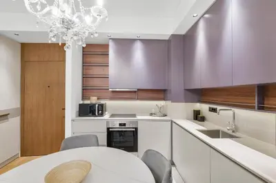 a kitchen with a white table and purple cabinets at BW Royal Dream in Belgrade
