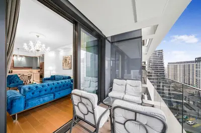 a living room with a blue couch and chairs on a balcony at BW Royal Dream in Belgrade