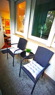 a porch with two chairs and a table and a window at ParkWest Arena Belgrade Lux Apartment in Belgrade