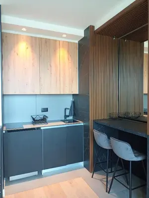 a kitchen with a black counter and some chairs at Beograd na vodi - BW City View in Sajmište