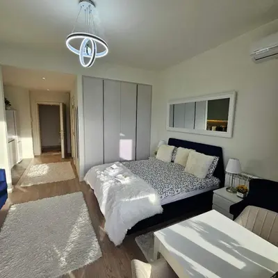 a bedroom with a bed and a living room at Belgrade Waterfront Galerija Apartment in Sajmište
