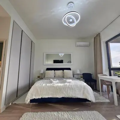 a white bedroom with a bed and a table at Belgrade Waterfront Galerija Apartment in Sajmište