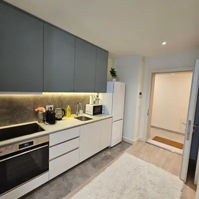 a kitchen with white cabinets and a refrigerator at Belgrade Waterfront Galerija Apartment in Sajmište