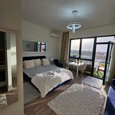 a bedroom with a bed and a table with a view at Belgrade Waterfront Galerija Apartment in Sajmište