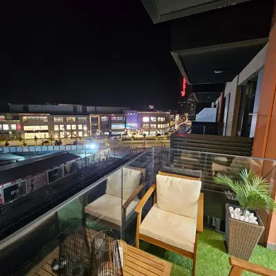 a couple of chairs sitting on a balcony at night at Belgrade Waterfront Galerija Apartment in Sajmište