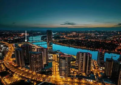 a city at night with a river and buildings at Exceptional Belgrade Waterfront Apartment - Beograd na Vodi in Belgrade