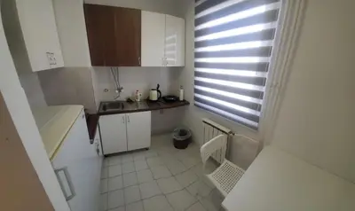 a small white kitchen with a sink and a window at Blok 2 in Belgrade