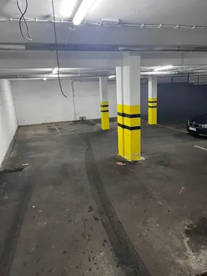 a parking garage with yellow and white columns and a car at Apartman Oki in Belgrade
