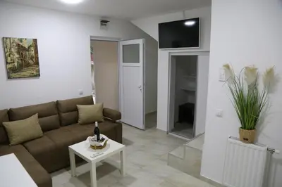 a living room with a couch and a table at Studio T&M, sa parkingom in Obrenovac