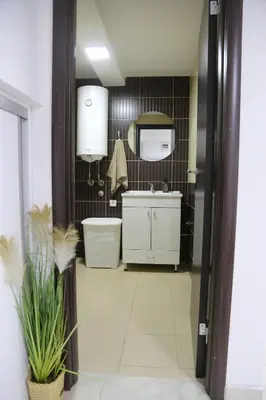 a bathroom with a sink and a toilet and a mirror at Studio T&M, sa parkingom in Obrenovac