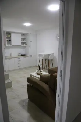 a living room with a couch and a kitchen at Studio T&M, sa parkingom in Obrenovac