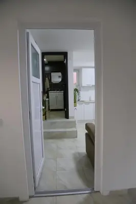 a view of a living room with a door into a room at Studio T&M, sa parkingom in Obrenovac