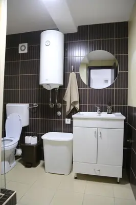 a bathroom with a toilet and a sink and a mirror at Studio T&M, sa parkingom in Obrenovac