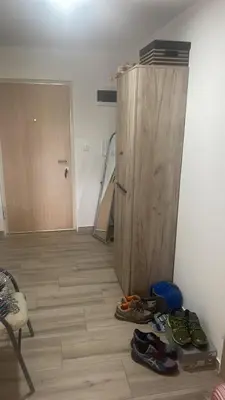 a room with a wooden door and shoes on the floor at Stan 3 UB in Ub