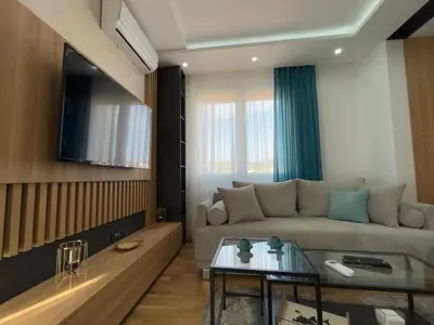 a living room with a couch and a tv at Perla Lux 2 Apartments in Arandjelovac